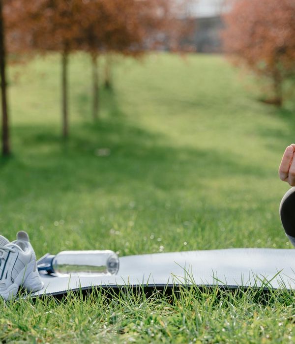 A calm space with a rolled yoga mat, water bottle, and quiet ambiance.